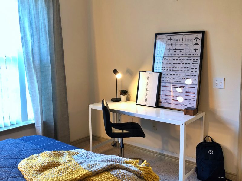 This image shows the working station inside the bedroom area featuring its luxurious desk with lampshade and light wall tone for a peaceful ambiance.