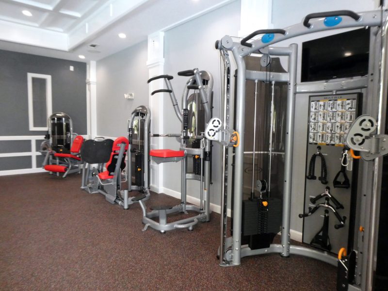 This image shows an expansive view of the community amenities, particularly the fitness gym featuring equipment for strength and chest workout.