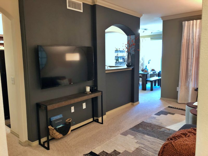 This image shows the living room area featuring a dark wall color, elegant furniture, and minimal wall decors that were suitable for a spacious area. The living room was also accessible to the dining area.