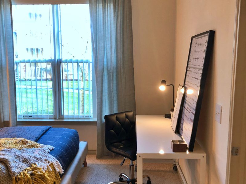 This image shows the Premium Apartment Feature, particularly the bedroom area showcasing the light tone color wall, elegant fabrics, and an overlooking view outside that was ideal for a comfy pleasure.