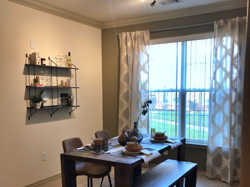 This image shows the Premium Apartment Feature, particularly the dining room area featuring minimalist decor, elegant furniture, and a wooden dining table that was suitable for a spacious area.