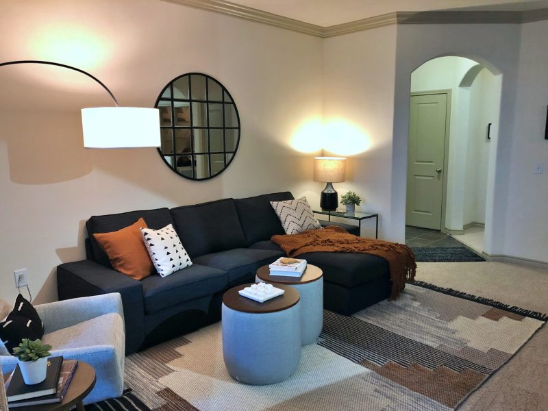 This image shows the living room area featuring a dark wall color, elegant furniture, and minimal wall decors that were suitable for a spacious area. The living room was also accessible to the dining area.
