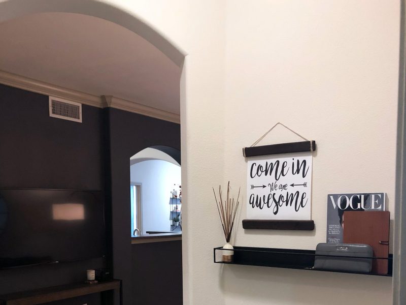 This image shows the premium feature in the living room area with minimal interior design that was ideal for a neat atmosphere. There are a TV and elegant wall decors.
