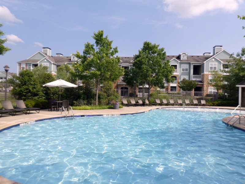 This image shows the resort-style outdoor swimming pool with a glittering sky blue water and pool beds for a lush tropical atmosphere for fun water experience.